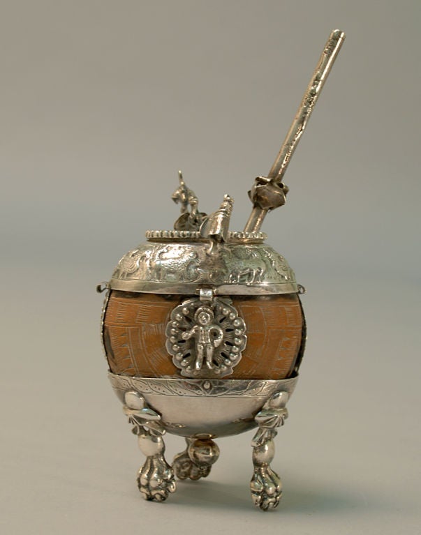 A good 19th century colonial mate cup with skillfully crafted silver repousse, large paw feet, birds, dogs, chickens and the original silver 'bombilla'.<br />
<br />
Dimensions: cup measures 5 inches high x 4 inches wide. Overall height, including