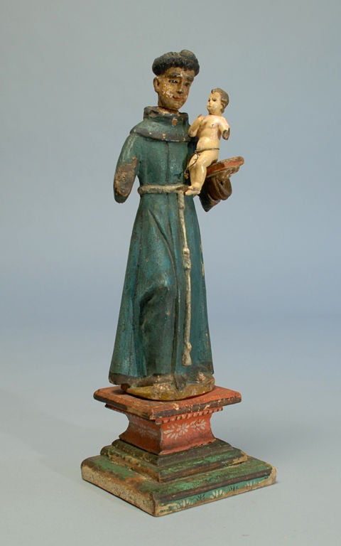 Saint Anthony, patron saint of lost articles, fertility, starvation, expectant mothers, amputees and shipwrecks, is represented in this charming 18th century figural santo. Carved and polychrome painted wood with inset glass eyes, painted wood base