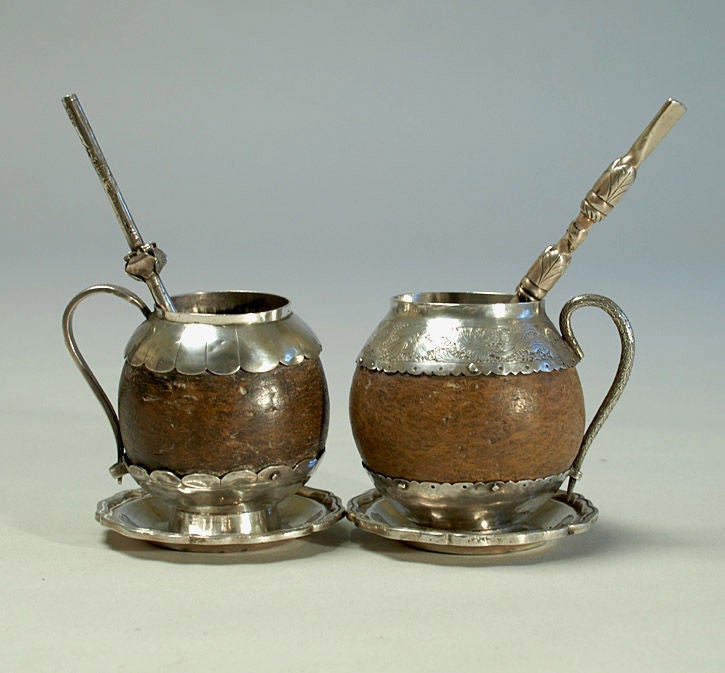 A pair of superb 18th century Spanish colonial silver mounted coconut mate cups. Beautiful hand chased silver with scalloped edges, foliate motifs, footed ring bases, scroll handles, bombillas and solid silver colonial saucers.<br />
<br