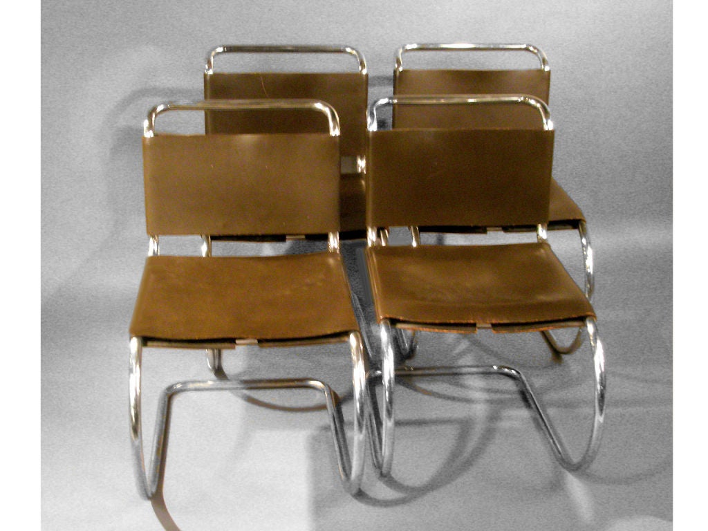 Classic set of tubular chrome chairs with chocolate brown saddle leather seats.