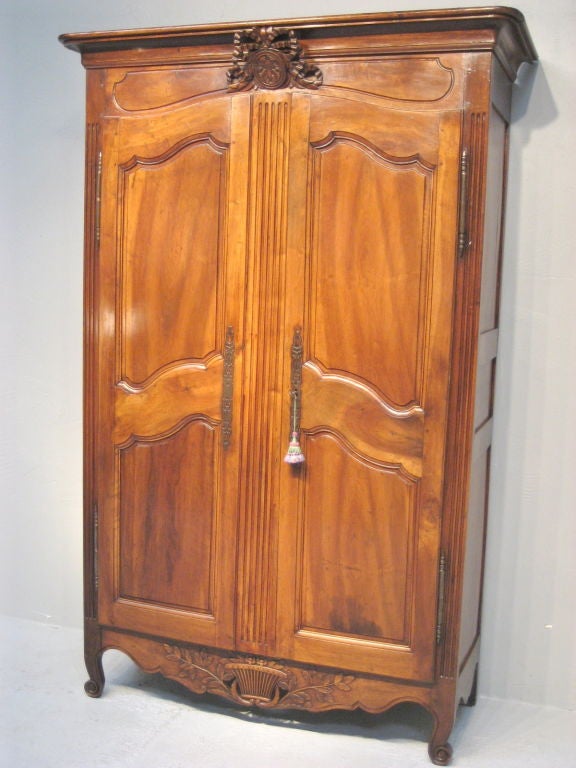 This lovely carved Provencal bridal armoire is made of walnut and has a wedding basket at the crown and a pierced apron. From the town of Ales, France. Some restoration on the back.