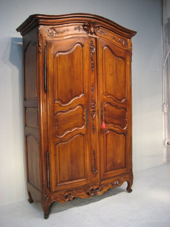 A exquisite walnut Armoire from Provence with 12 raised panels, a pierced apron, and a carved basket on a Chapeau de Gendarme crown.<br />
This armoire remains in its original condition.<br />
<br />
MORE ANTIQUES AVAILABLE AT WWW.OFLEURY.COM