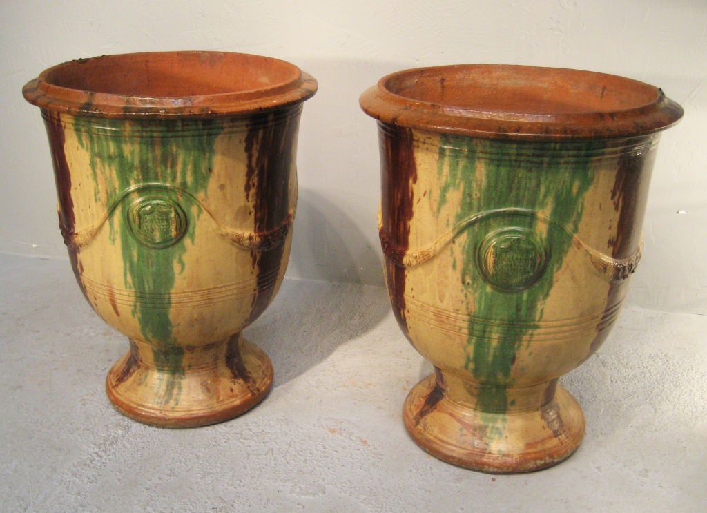 Pair of  exquisite Vases d'Anduze from the south of France. These large pottery planters have a classical urn form and rich color palette of ochre, terra cotta and verdigris. Made at the factory of 