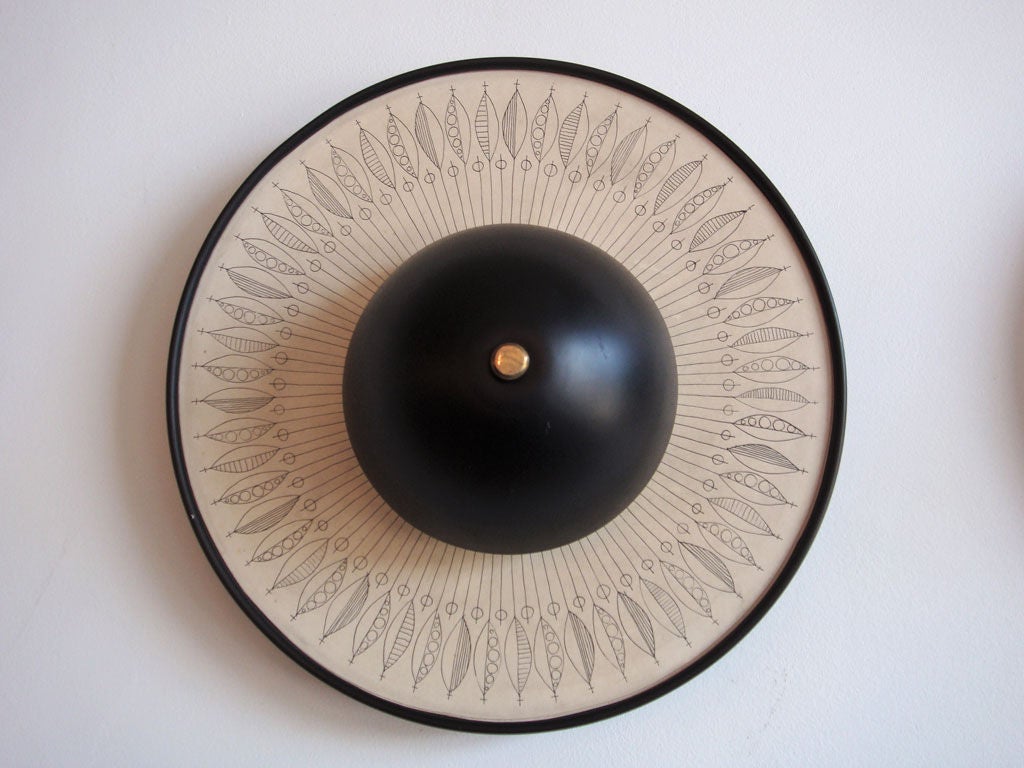 backlit disk sconces in black and off white<br />
decorative leaf pattern