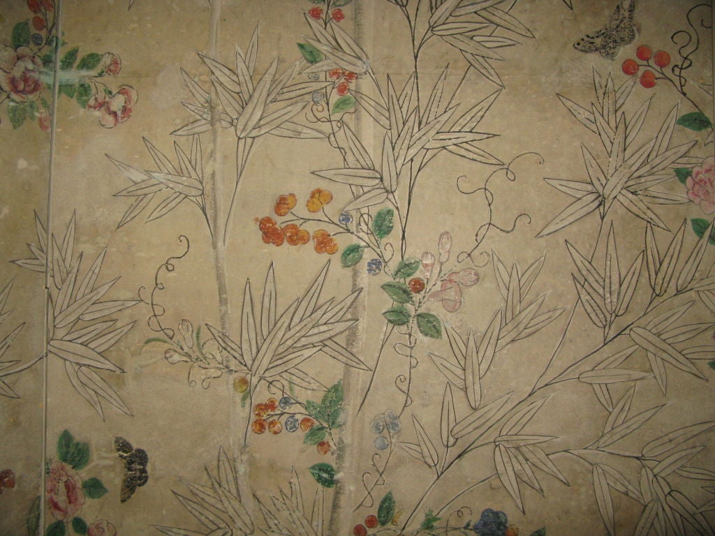 A finely painted 18th century Chinese wallpaper with scenic design of bamboo, vines, rocks, groundwork, butterflies and birds on an uneven beige colored background. The wallpaper has been applied to a four panel screen. 

Please note: A pair of