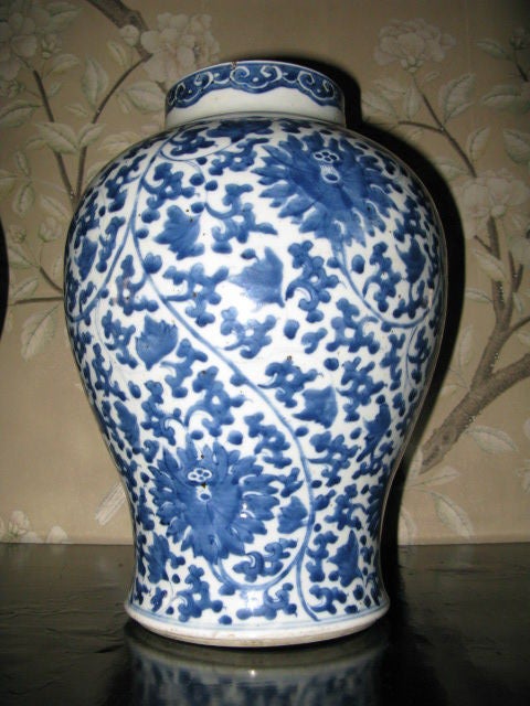 A pair of Chinese blue and white temple jars from the Kangxi Period (1662-1722).  All over design of blue peonies and vines on a white background.  Unmarked on bases.  Interesting border design at neck.