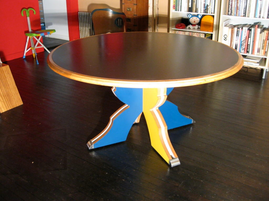 A great and important dining/center table designed by Robert Venturi and produced by Knoll in 1984.  Base is of plywood and colored laminate with chromed metal caps at the end of the feet. The top is double sided black laminate with a solid maple