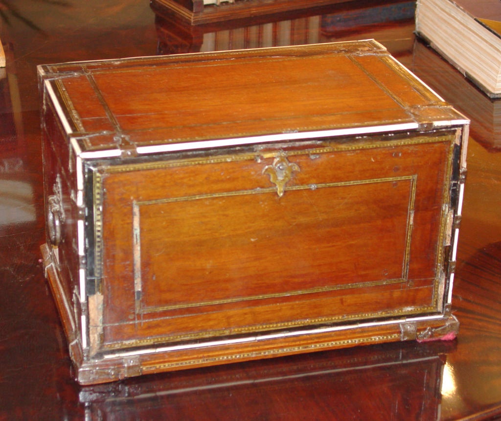 Indian lock box with ivory drawer fronts featuring intricate inlay and panels that have been tinted in red and green.  Small iron teardrop pulls hang from each drawer.  The mahogany case is mounted with iron handles and bindings along with more