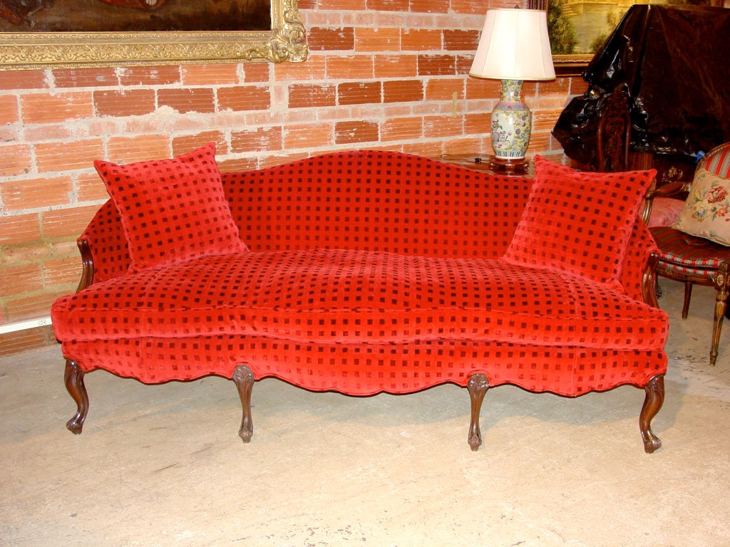 18th Century English Settee with arms and legs of mahogany.  Upholstered in a red patterned velvet with slightly raised checks/squares in the fabric.  Two pillows.