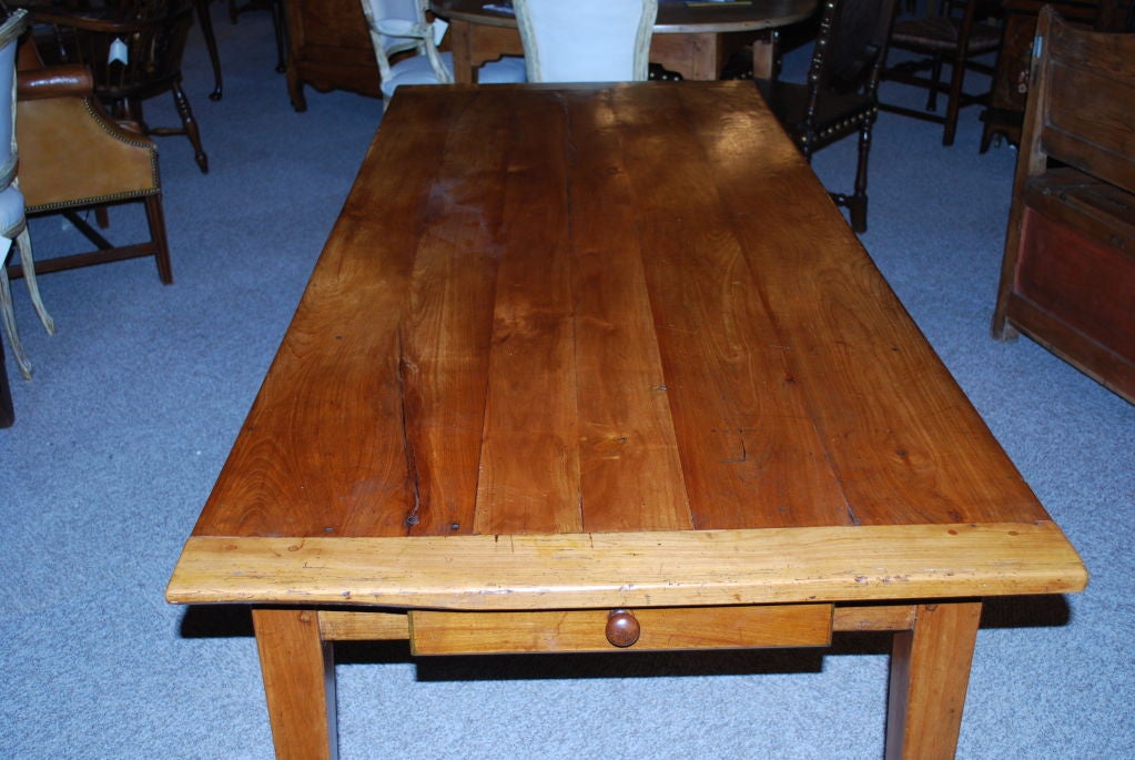French narrow faded cherrywood farm table with 1 drawer at the end & 4 tapered legs.