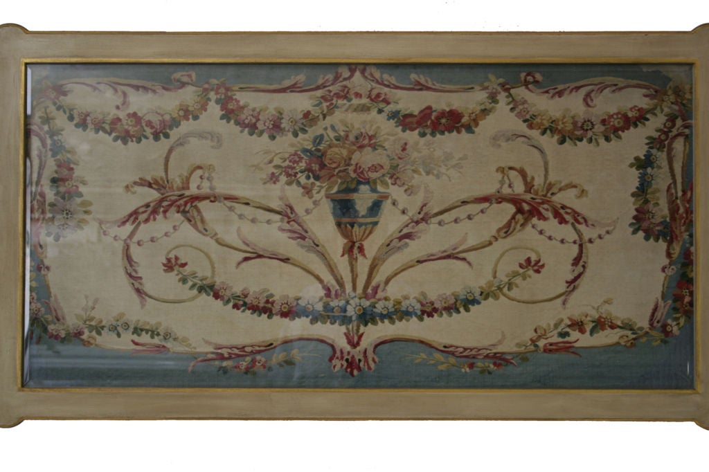 An 18th century blue and beige aubusson panel, now mounted under glass in a cream painted and parcel gilt Adam's style cocktail table base.