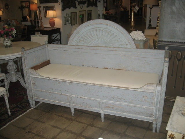 Swedish daybed painted in a wonderful shade of pale ice/blue. The four finials and carving throughout are typical of the period. The back rail is beautifully detailed with a half-round fan carving.