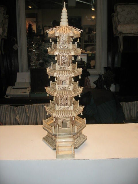 Pair of 1970's Chinese Carved Bone Pagodas. Incised carving details as well as ornate fretwork designs. An antique finish highlights the intricate carving detail. Carved bells hang from the rooflines.