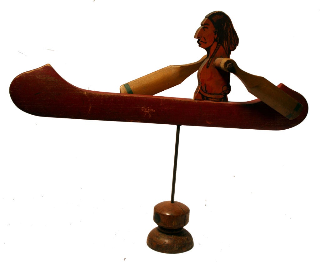 This beautiful whirligig, made of carved wood which was hand painted, depicts an Indian in a red canoe with yellow paddles. It was crafted by a naive artist in NEw England. Whirligigs were creatively used to keep unwanted animals out of the garden.