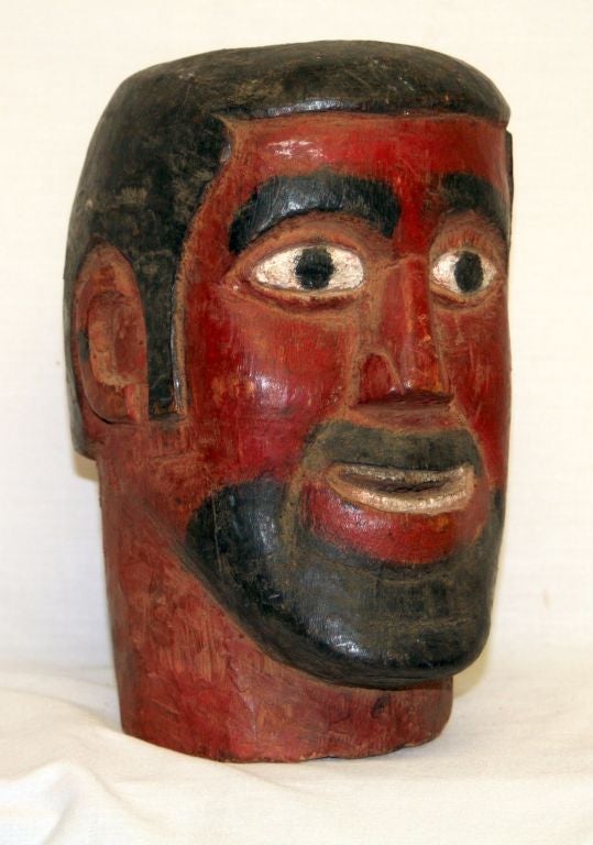 Made in Chichicastenango, Guatemala, this carved head depicts Maximon, also known as San Simeon or San Simon. It is polychrome painted wood with a red head, white eyes, black beard, and a removable black hat. This wonderful and whimsical carved head