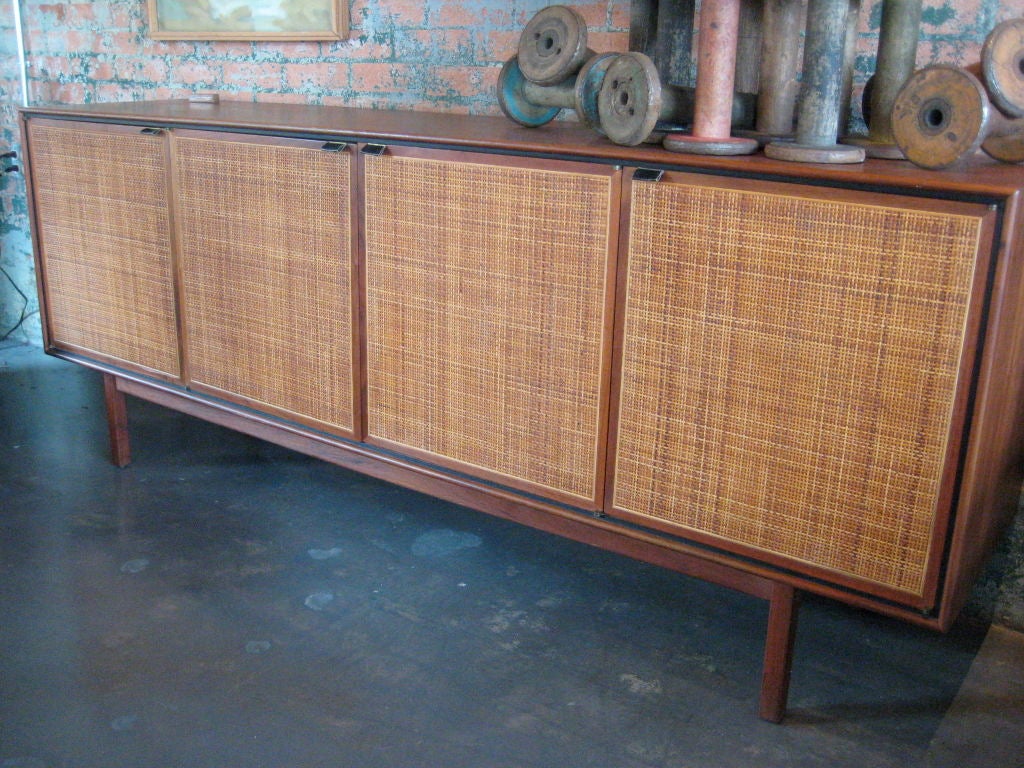 A very nice walnut credenza with caned doors and leather pulls.