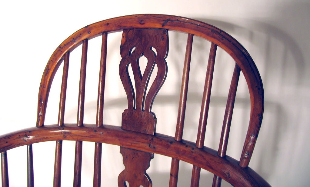 Circa 1840; North East Midlands. Each with a low hoop back with stylized fleur-de-lis pierced fretted top splat with two extra piercings and two shaped frets in lower splat; the armrests with turned supports; raised on turned legs joined by a