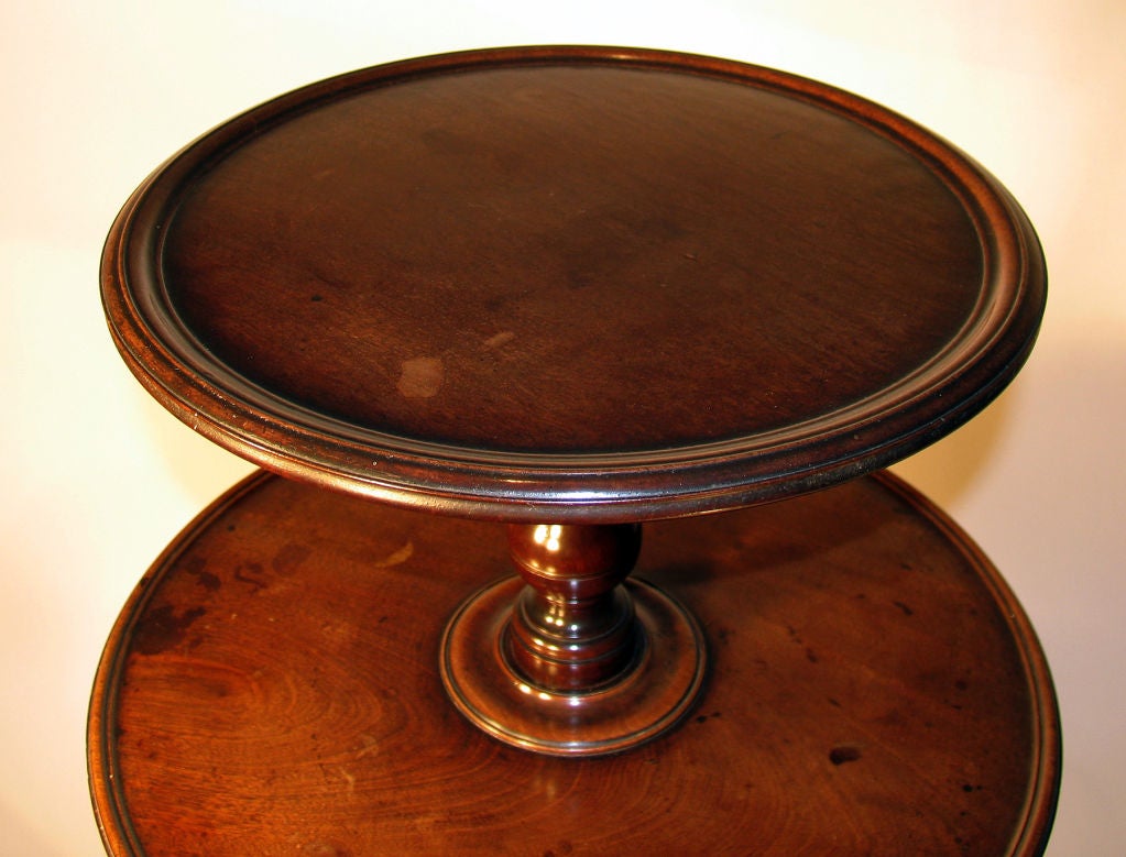 Circa 1770. Three rotating graduated circular tiers with moulded edge are connected by a baluster-turned central stem; raised on cabriole legs ending in slipper feet on castors.