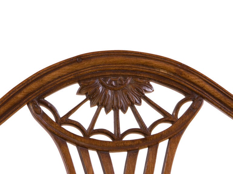 English George III shield back settee with finely carved 
shield backs, shaped arms a over upholstered seat with tapered
legs ending in spade feet.