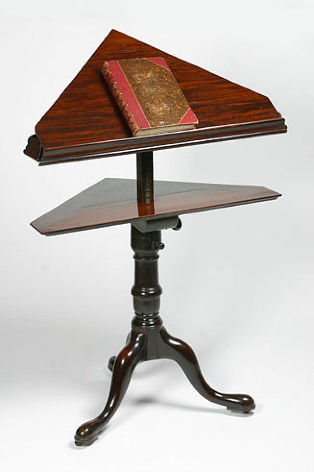 Unusual George II mahogany corner reading stand with a triangular

adjustable top raised on a urn shaped pedestal with a tripod base

having shaped legs ending in pad feet