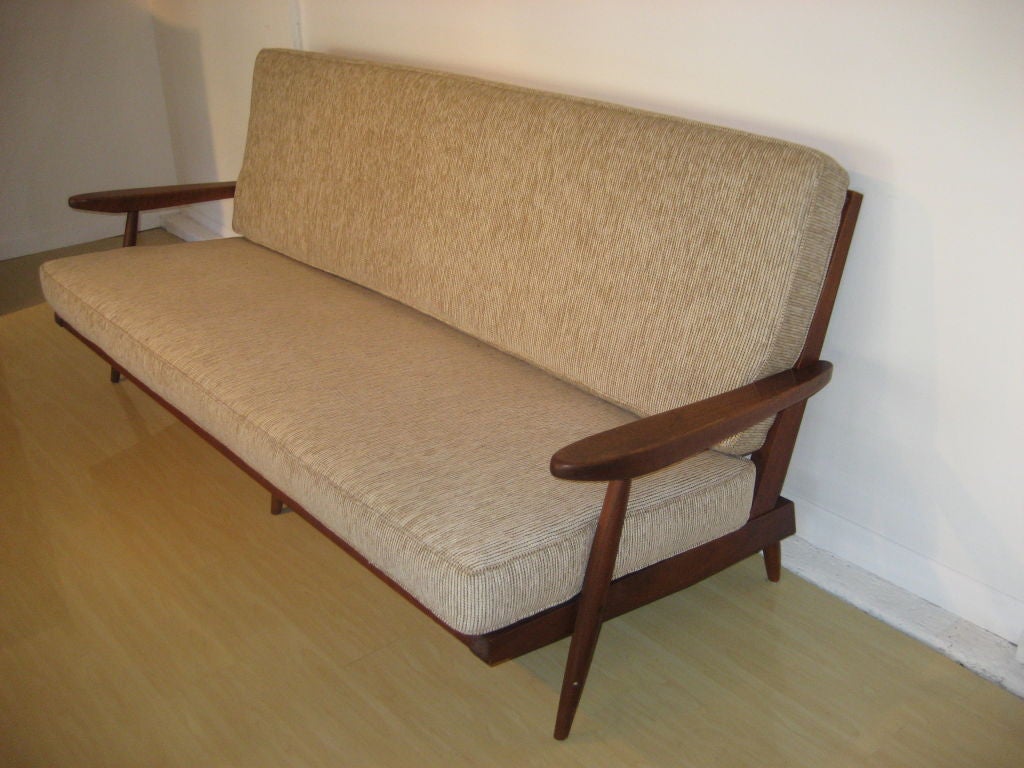 A terrific spindle-back six-foot sofa with arms, with newly done beige chenille upholstery. Provenance accompanies.