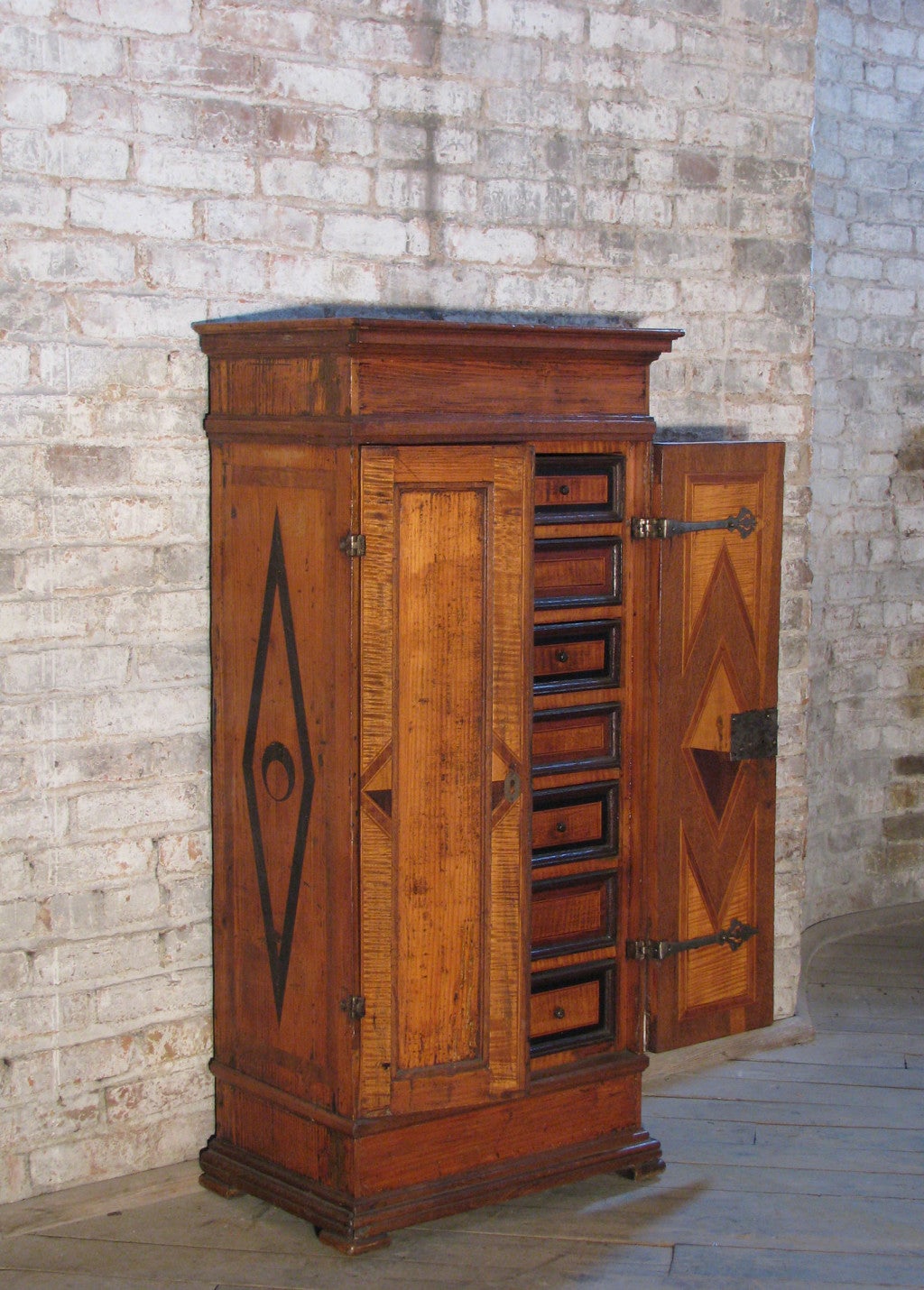 Charming, small Alpine cabinet, likely Swiss, with geometric inlaid decoration and ebonized moldings, the double doors opening to an interior fitted with drawers.
