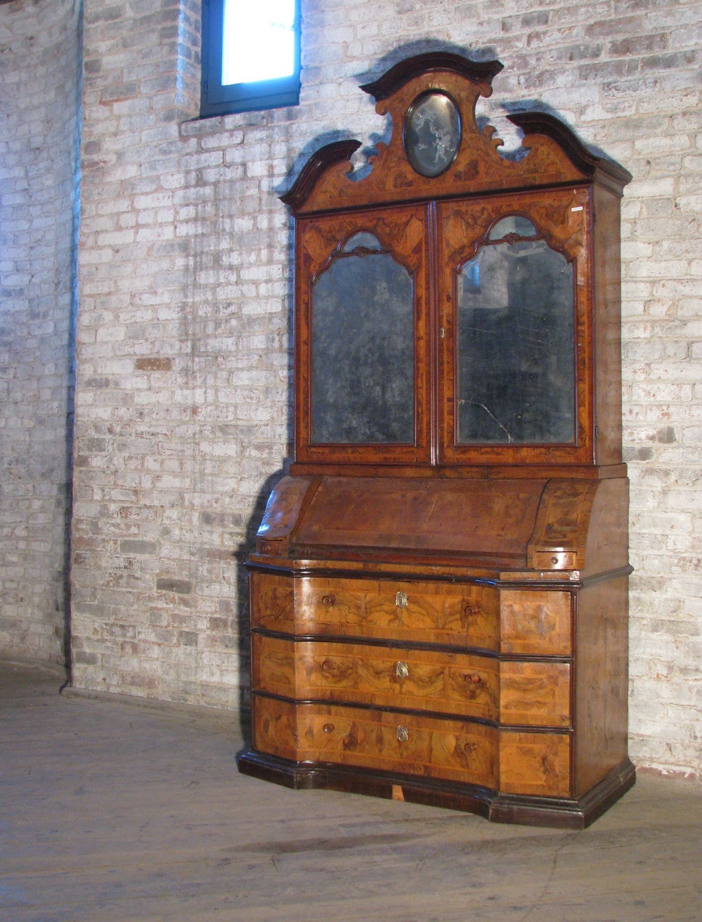 Italian secretary with beautiful, thick walnut radica veneer, wonderful color, ebonized moldings, most likely retaining the original mirror plates. The two upper doors open to reveal a fitted interior, the lower part has a fitted desk compartment