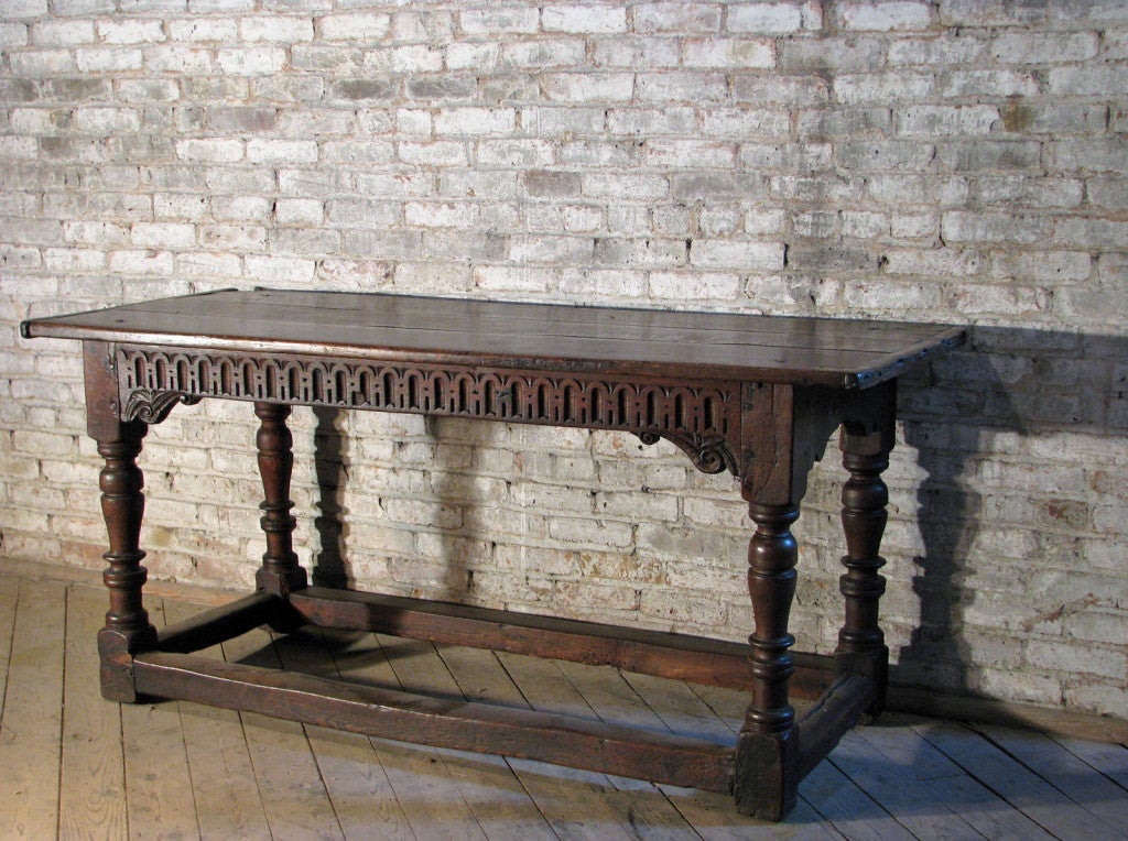 Beautiful refectory table, the frieze with carved decoration to the front, the turned legs joined by box-stretcher. Rich and deep color