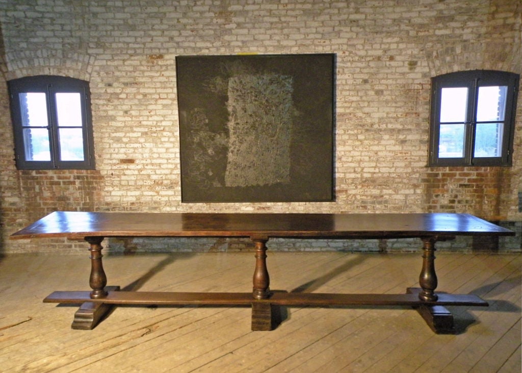 Extraordinary and unusual long and narrow trestle table. The top supported by three beautifully shaped baluster legs connected by a flat stretcher, on three shoe feet. Measures: 13 foot long.

