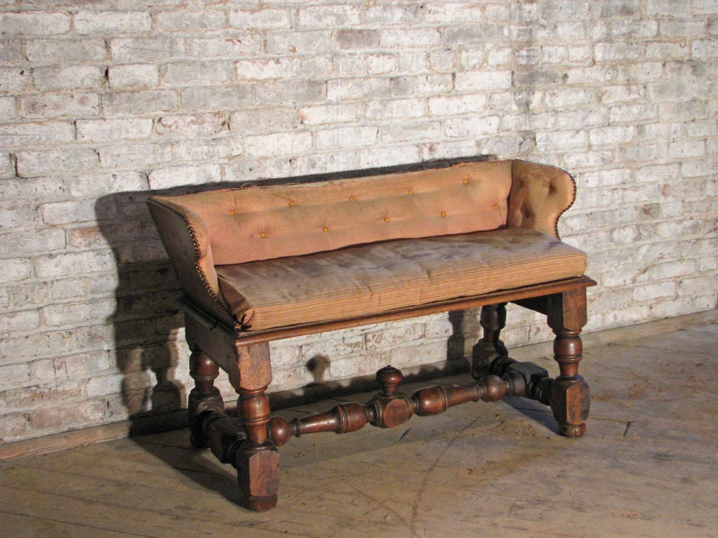 Unusual upholstered banc with a low backrest, the seat supported by strong turned legs joined by conforming H-stretcher and . This is the one and only original! 