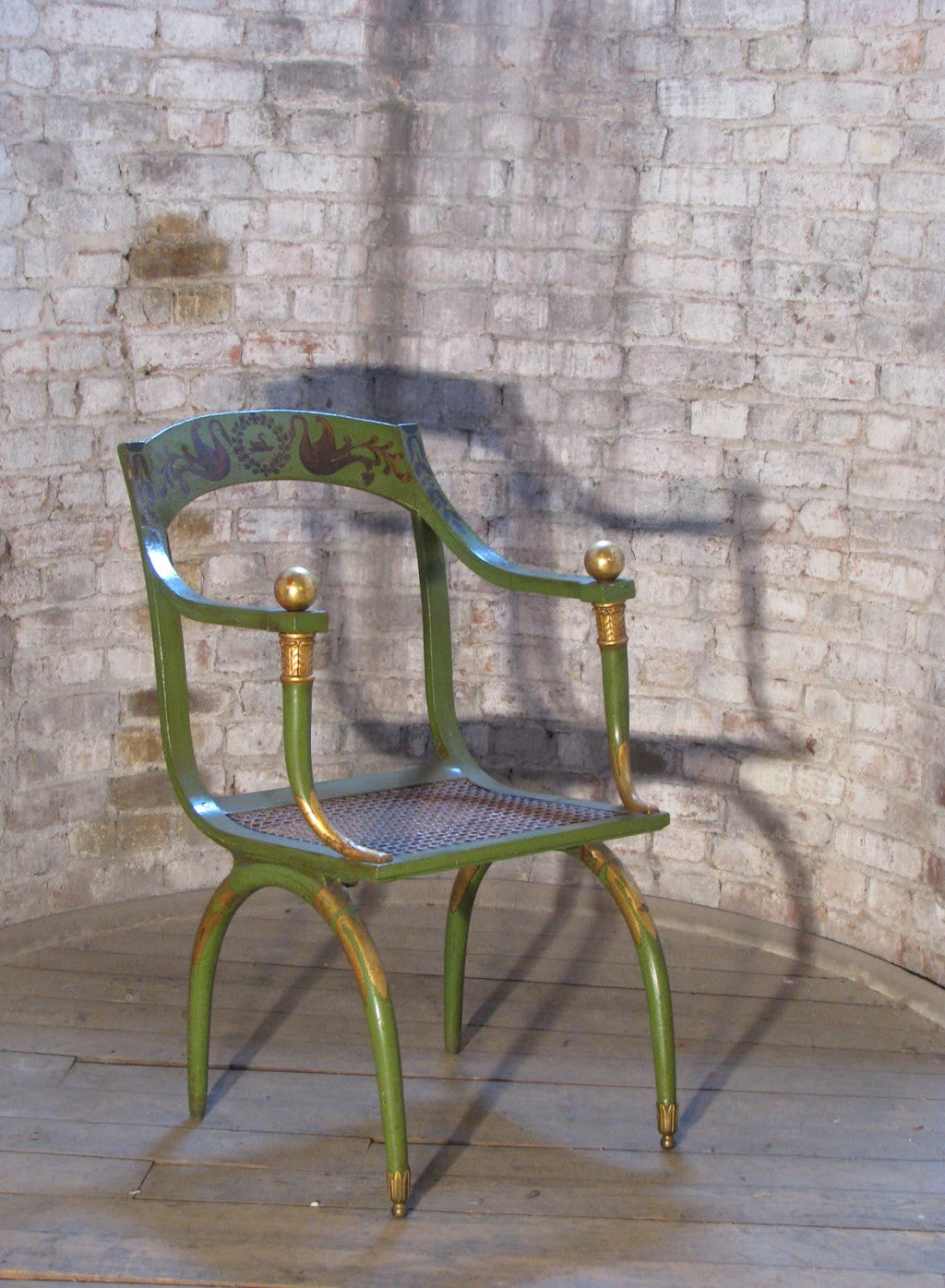 Neoklassizistischer, grün lackierter und vergoldeter Sessel mit Rohrsitz.
Nach einem Modell von Jean-Joseph Chapuis.
Die vorderen Beine haben ihre Messingrollen behalten, bei den hinteren Beinen fehlen die Rollen.
