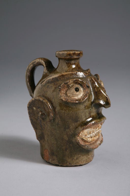 These face jugs were made of three different kinds of clay used to highlight the facial features. The jugs were often used to store water. Enslaved potters in the rural South often produced these jugs. <br />
<br />
This jug has a wonderful rich