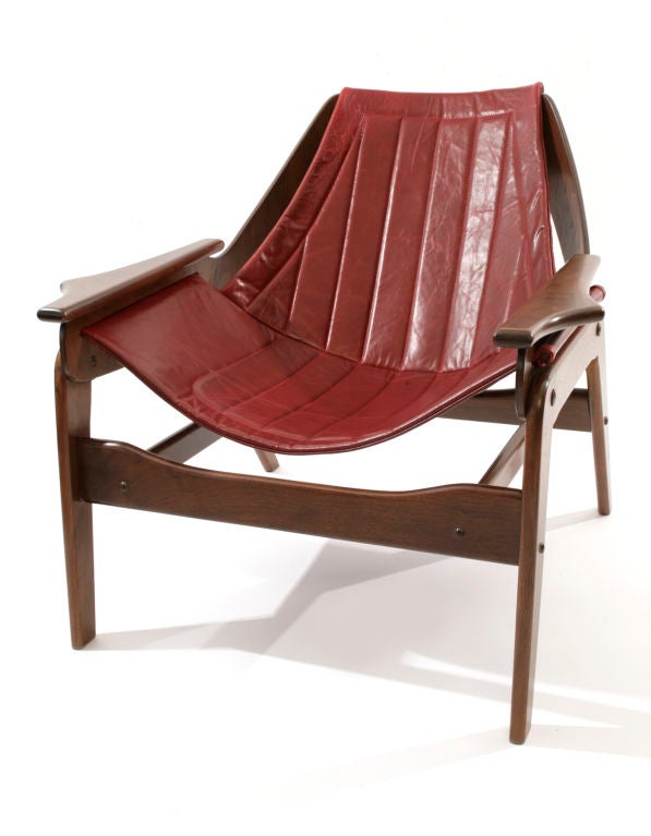 Jerry Johnson leather and walnut sling chairs circa 1964. Feature solid walnut frames with sculptural detailing to the arms beautifully curved backs and new red leather slings. Newly refinished and upholstered. The patents were applied for these