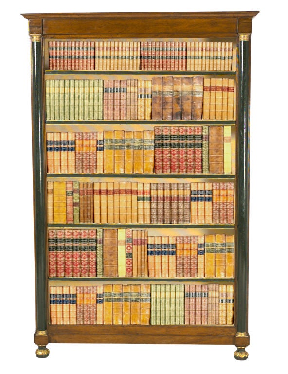 A mahogany bookcase with half-round painted pilasters with brass capitals and pedestals. Raised on carved and gilded bun feet. Also with five adjustable shelves.