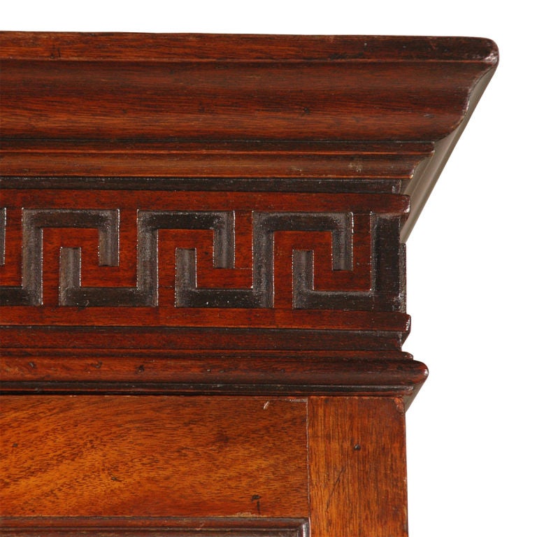 A mahogany display cabinet with Greek key blind fretwork just below the molded cornice and blind fretwork of interlocking circles just below the molded waist. The lower section is fitted with the original drawers. With very good color.