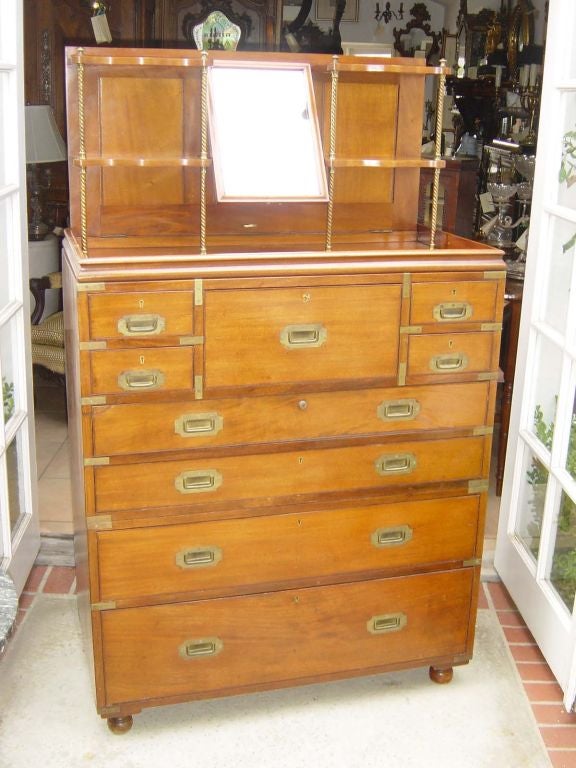 An unusually elaborate English mahogany campaign chest with lift top shaving mirror and shelves, and a pull out leather topped writing drawer fitted with compartments for ink pots and pens, and reading slope. Breaks down to two sections, with the