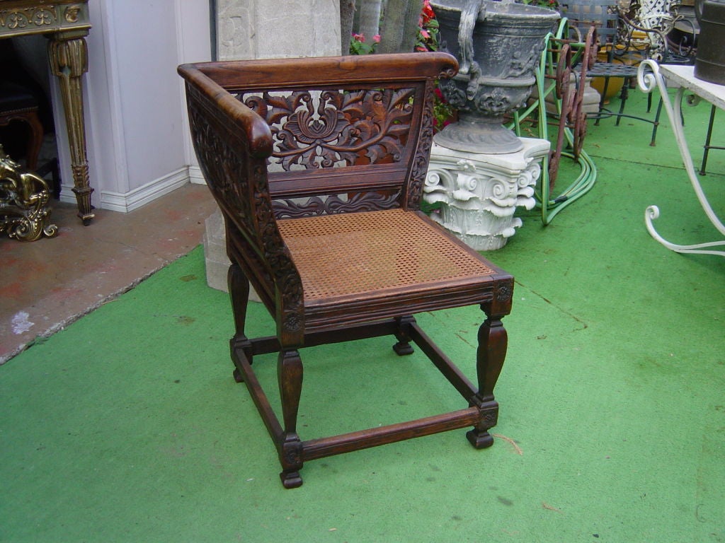 A highly pierced and carved Dutch Colonial corner chair with cane seat (redone with  inset woven cane).  This form originated in the 17th century with the so called 