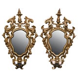 A pair of gilded fir wood mirrors with wrought iron candle arms
