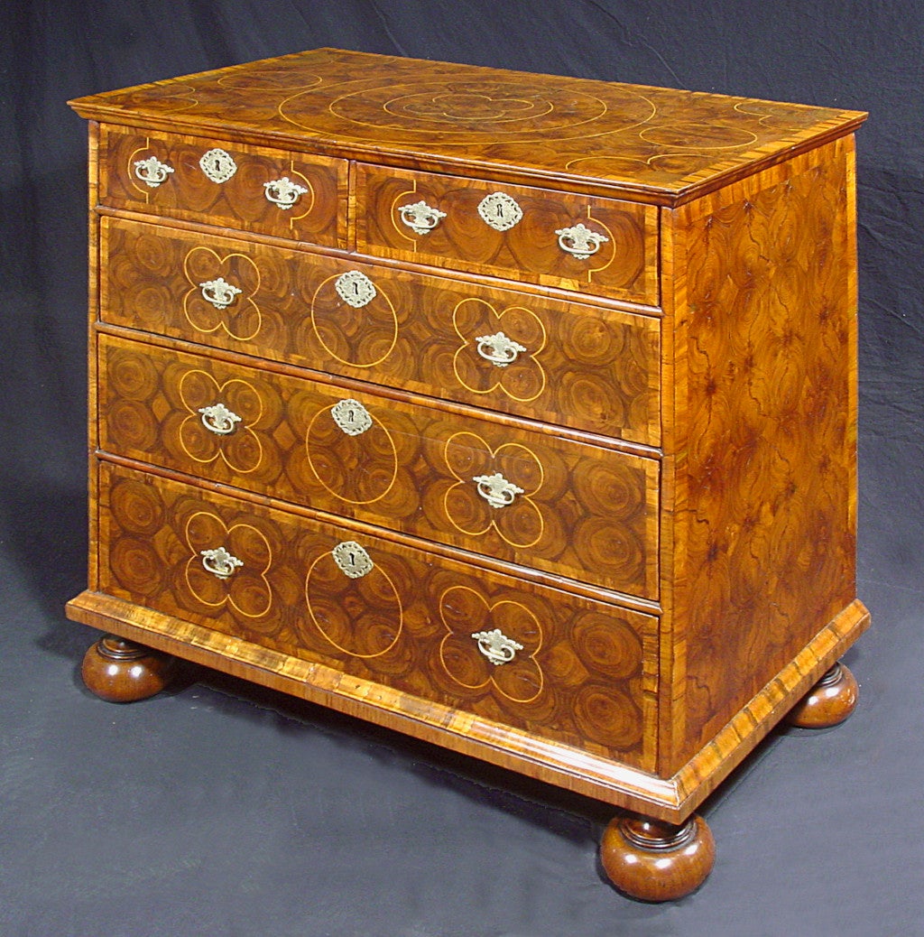 The rectangular top over two short above three long graduated drawers, on later bun feet; inlaid throughout with geometric stringing.