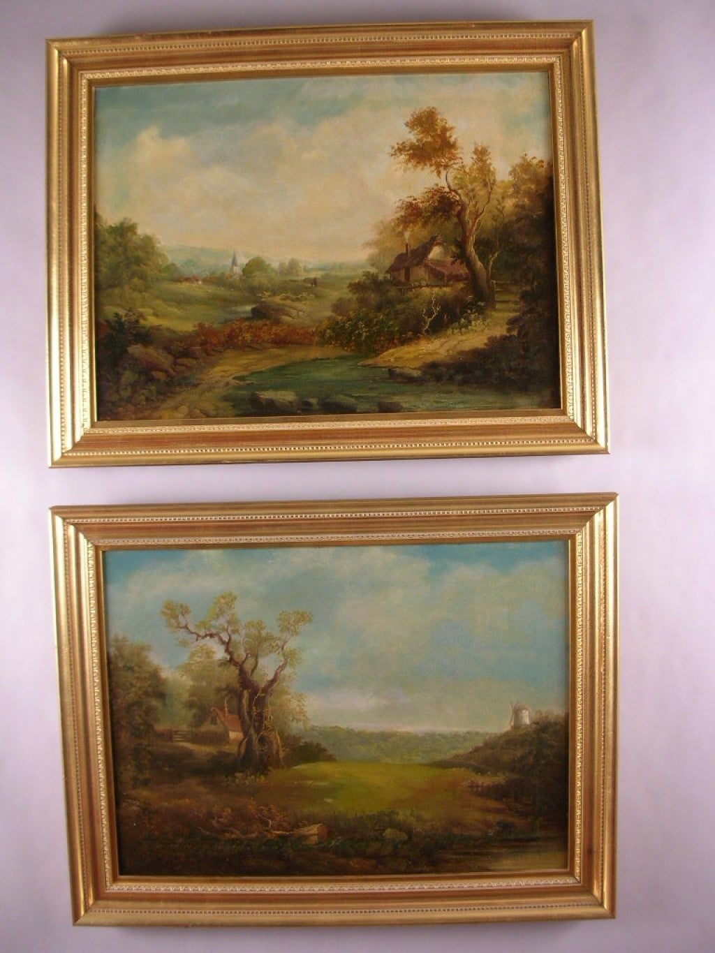 Rare pair of landscape paintings, signed C. Baker, each in a modern giltwood frame.
