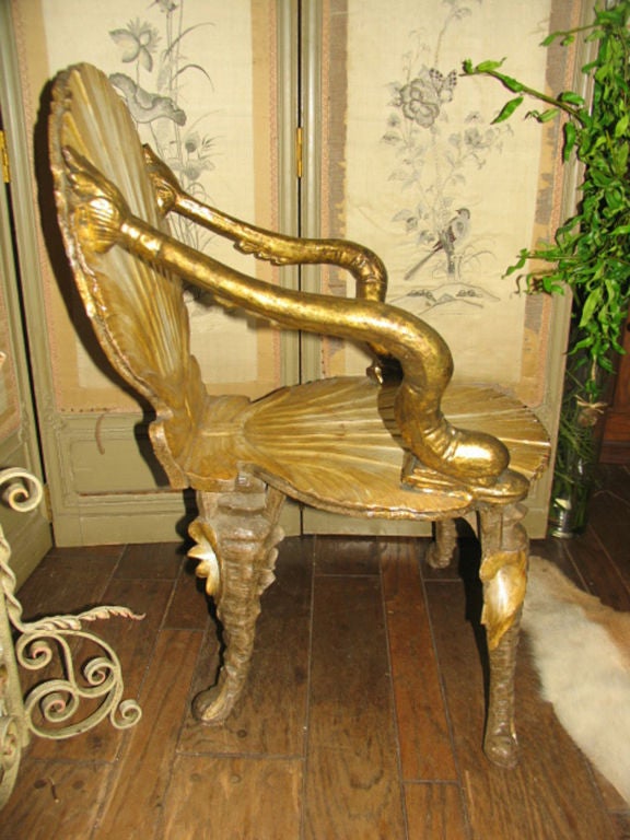 Italian handcarved silver gilt grotto armchair features stylized shell seat and back with arms in the form of dolphins all raised on splayed legs carved as oyster shells.