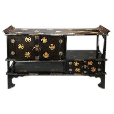 Japanese Black Lacquer Tana (Tiered Tea Cabinet) with Gold Family Crests, Covered with gold family crest designs.  Made of lacquered wood and bronze mounts.  Interior has wonderful renderings in gold of the gods of Japan (Ebisu and Daikoku), as well