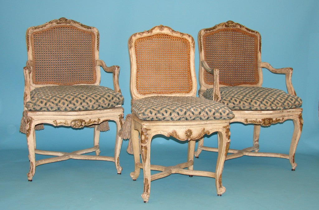 Set of 12 painted and caned dining chairs
