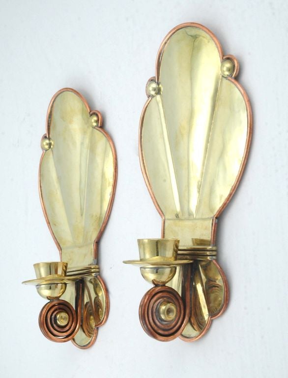 A rare pair of circa 1940 brass and copper sconces by Hector Aguilar of Taxco, Mexico, the candleholder back made of brass, brass balls are part of the decoration, there is copper 'piping' around the entire rim and at bottom of candleholder, with