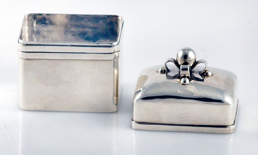 A fine, circa 1945 sterling silver tea caddy by William Spratling, of Taxco, Mexico, with three applied bands of silver, the lid with curled ribbon-like bands of silver applied with 'beads,' with a large central ball on 'ribbons.'

Weight 16 oz.