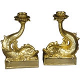 Fine pair of fire gilt terracotta dolphin form candlesticks