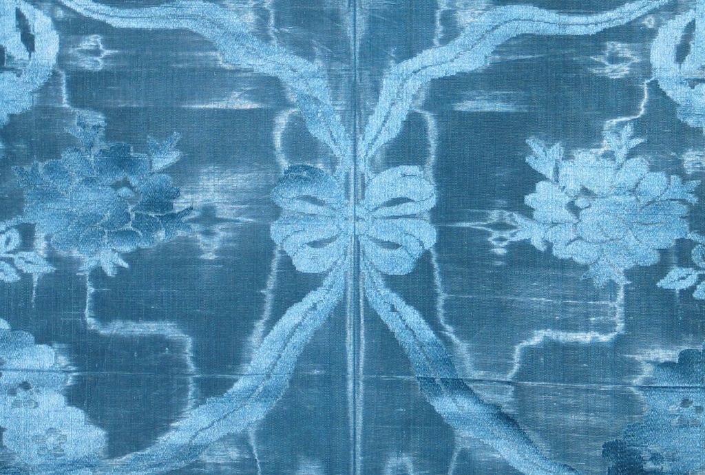 A rare c. 1750 French (Lyon) sapphire blue moire silk damask patterned with a floral swag up the sides and a ribbon swag in the center.