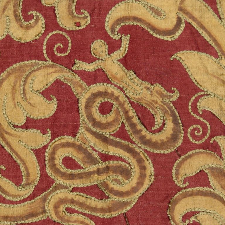 Late 17th century Italian hanging with a red silk ground and silk gold applique painted to articulate the scrolling tendril and vine pattern,  including a motif of a crowned snake with a man in its mouth at the four corners, one in the center.The