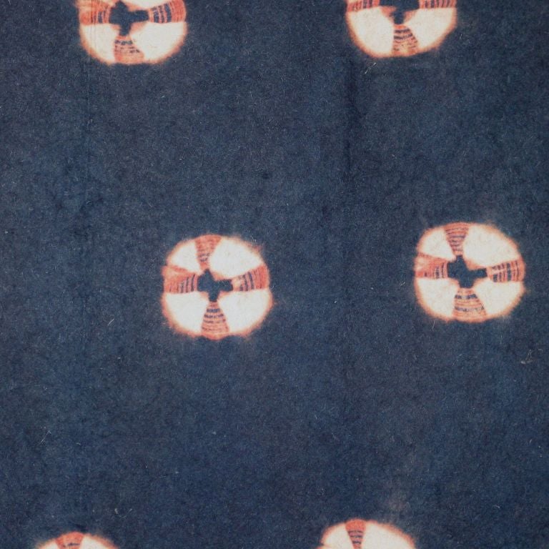 Late 19th century Japanese resist dyed (shibori-zome) wool felt carpet (shiborimosen) with a navy blue field and resist roundels in a caramel color. Called 