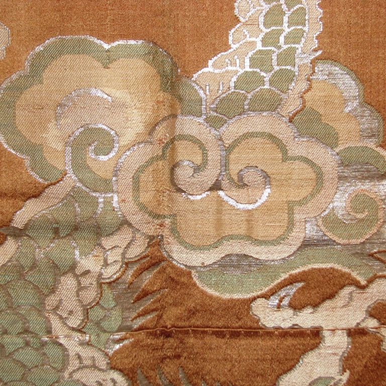 Japanese kesa (Buddhist monk's garment) made from copper colored kinran brocade patches that are joined together.  The brocade is patterned with dragon tails and clouds.